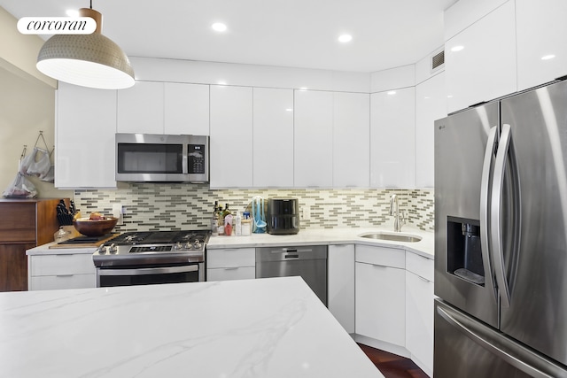 kitchen featuring a sink, stainless steel appliances, modern cabinets, and white cabinetry