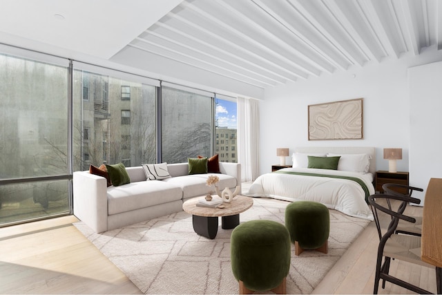 bedroom featuring light wood-style flooring and beamed ceiling