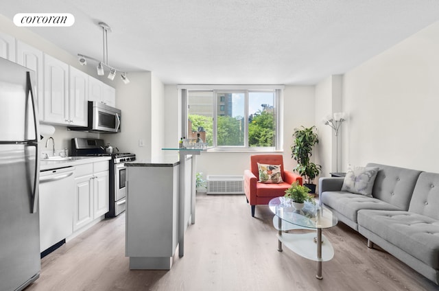 kitchen featuring white cabinetry, visible vents, open floor plan, and stainless steel appliances