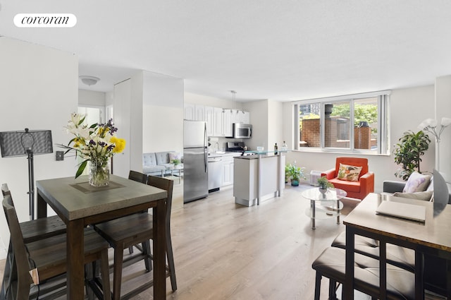 dining space with visible vents and light wood-type flooring