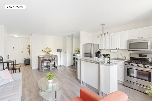 kitchen featuring visible vents, light countertops, appliances with stainless steel finishes, white cabinetry, and a sink