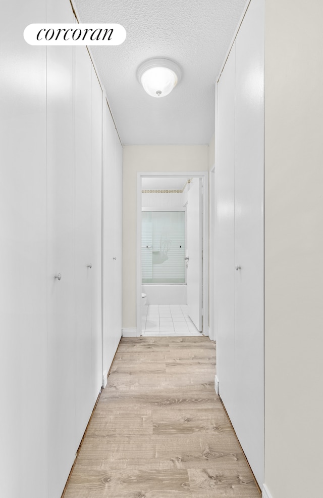 345 E 93rd St Unit 2E, New York City, NY 10128 - hall featuring light wood-type flooring and a textured ceiling