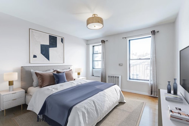 bedroom with light wood-style flooring, visible vents, and baseboards