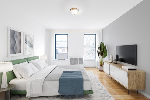 bedroom with visible vents, light wood-style flooring, and baseboards