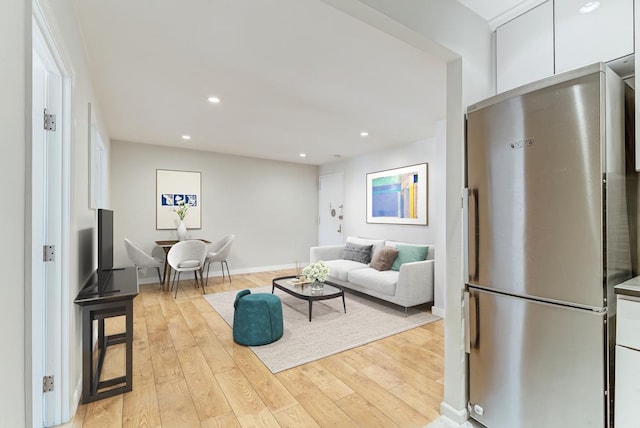 living area with light wood-type flooring, baseboards, and recessed lighting