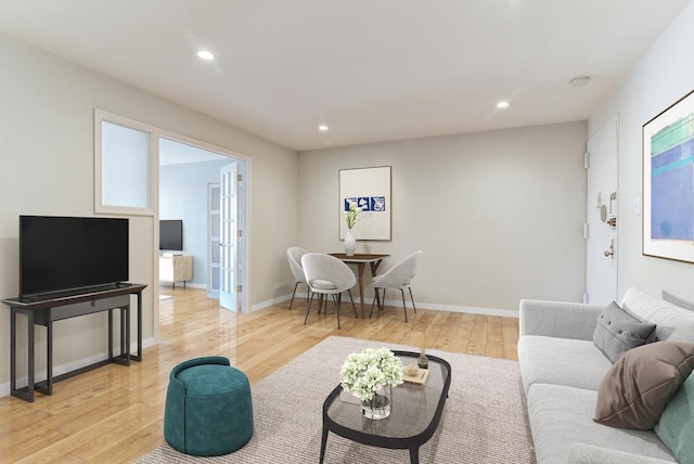 living area with light wood-type flooring, baseboards, and recessed lighting