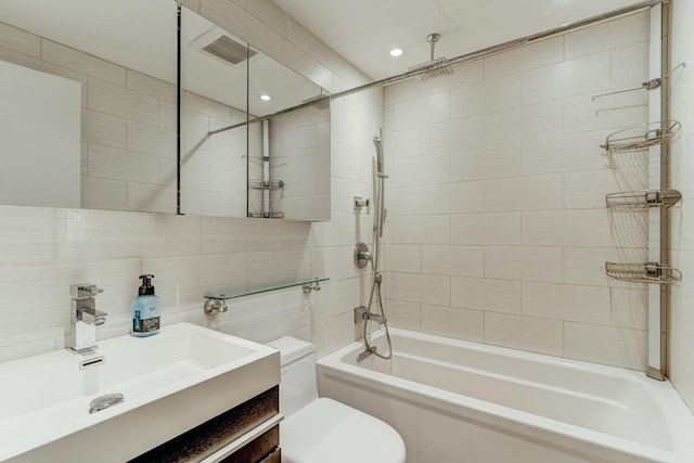 full bathroom featuring tile walls, visible vents, toilet, a combined bath / shower with rainfall shower, and vanity