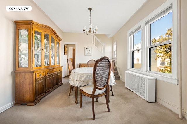 dining space featuring light carpet, visible vents, baseboards, radiator heating unit, and an inviting chandelier