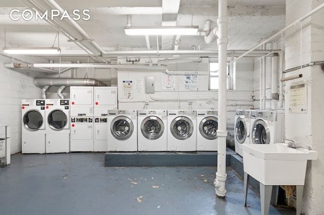 community laundry room with washing machine and dryer, stacked washer / drying machine, and a sink