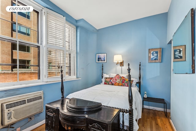 260 W 10th St Unit 2W, New York City, NY 10014 - bedroom featuring wood finished floors, baseboards, and a wall mounted air conditioner