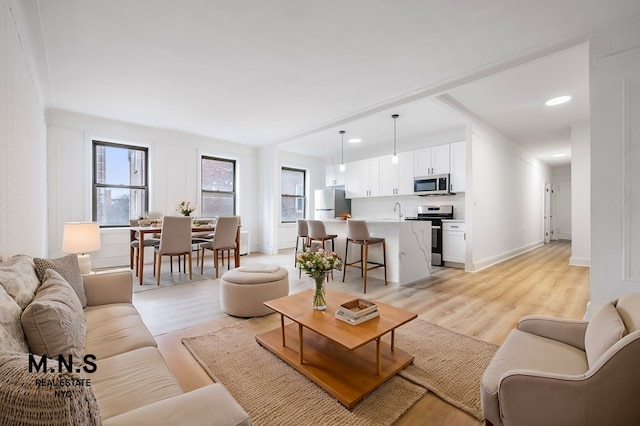 living area featuring recessed lighting, light wood-style flooring, and baseboards