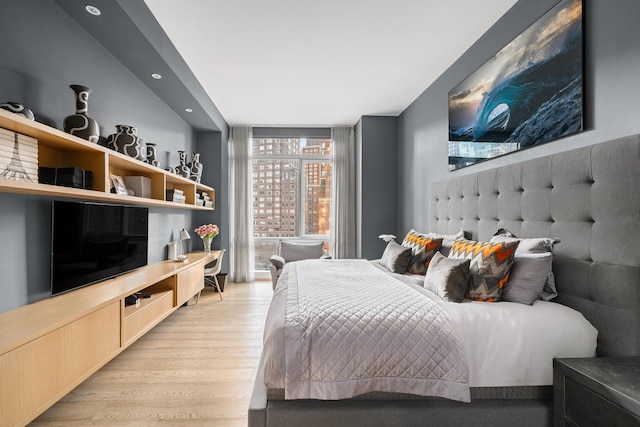 bedroom with a wall of windows, light wood-style flooring, and recessed lighting