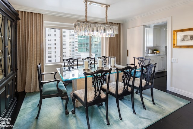 dining room featuring dark wood-style floors, ornamental molding, and baseboards