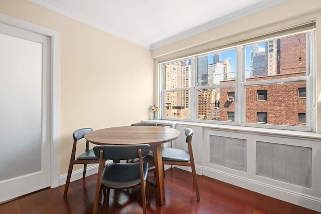 dining area with dark wood-style floors, baseboards, and ornamental molding