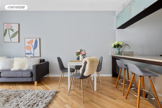 dining area with visible vents, light wood-style flooring, and baseboards