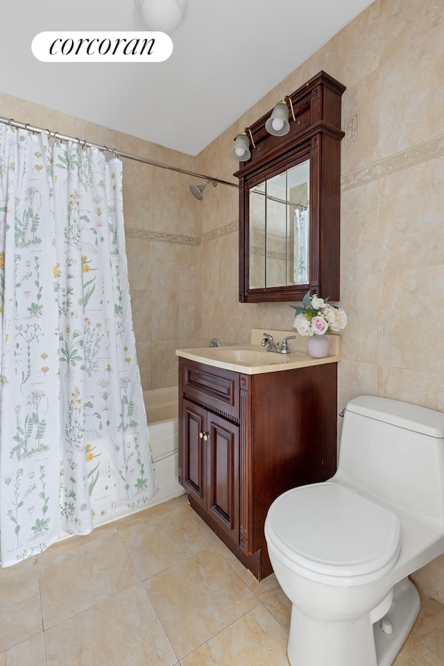 full bathroom featuring tile patterned flooring, shower / bath combo with shower curtain, vanity, toilet, and tile walls