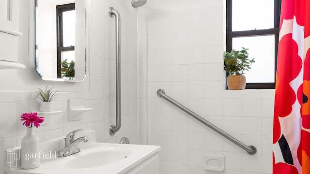 full bath featuring curtained shower, tile walls, and vanity