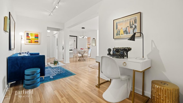 home office featuring wood finished floors and track lighting