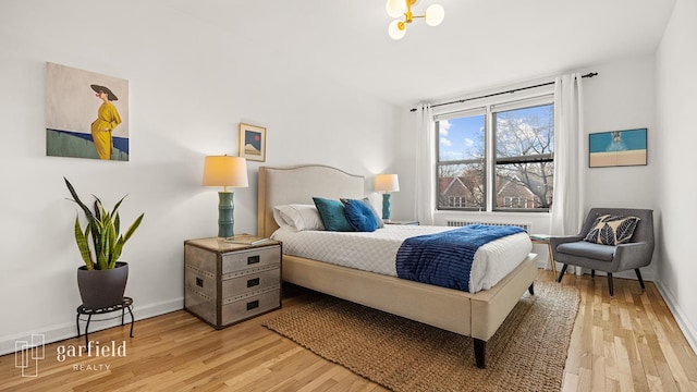 bedroom featuring light wood finished floors and baseboards