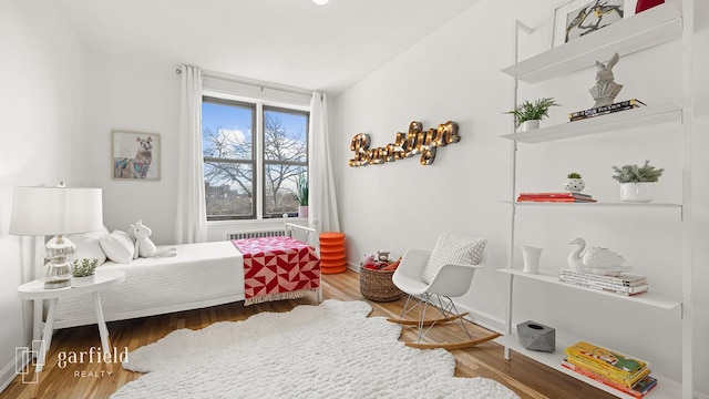 bedroom featuring baseboards, vaulted ceiling, and wood finished floors