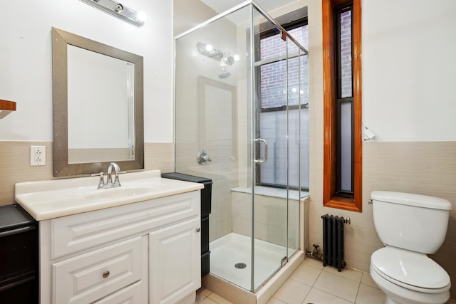 bathroom featuring radiator, toilet, a stall shower, vanity, and tile patterned flooring