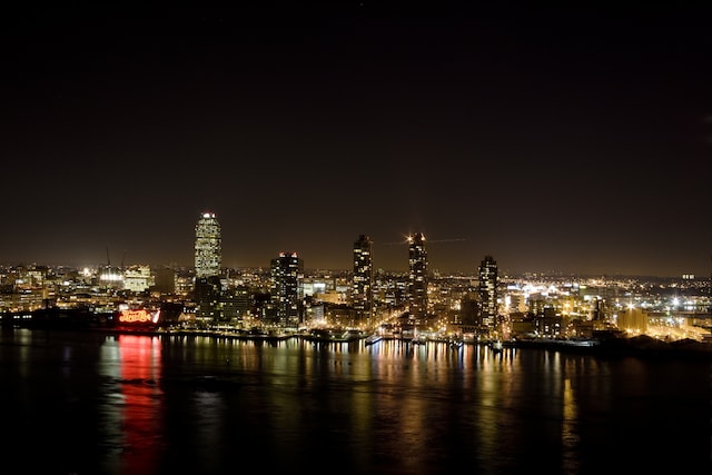 property view of water featuring a view of city lights and a boat dock