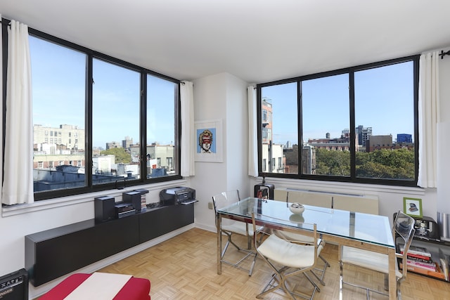 dining room with a view of city, a healthy amount of sunlight, and baseboards