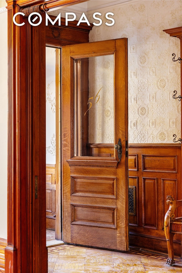 interior details with a wainscoted wall and wallpapered walls