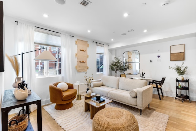 living room featuring light wood-style floors, recessed lighting, visible vents, and a healthy amount of sunlight