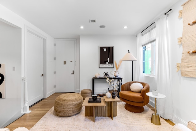 living area with recessed lighting, baseboards, and wood finished floors