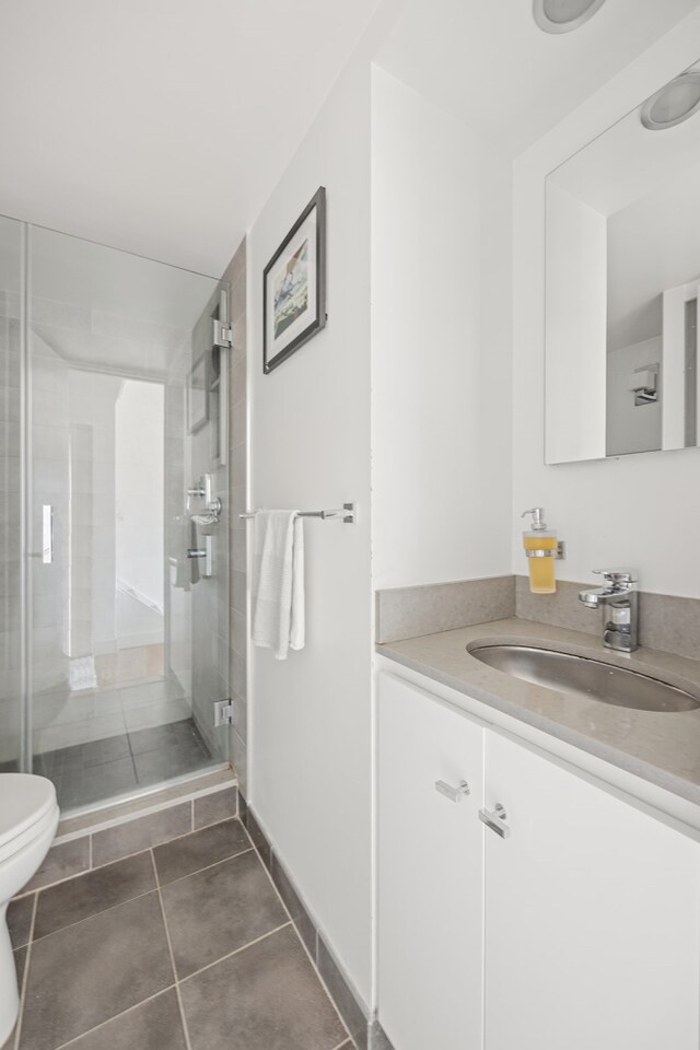 full bath with toilet, a shower stall, tile patterned flooring, and vanity