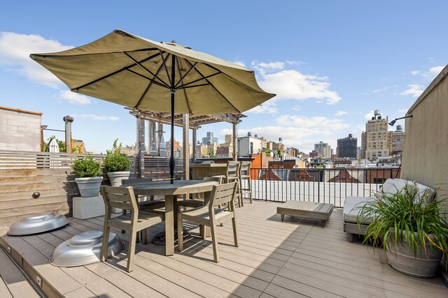 wooden deck featuring a view of city and outdoor dining area