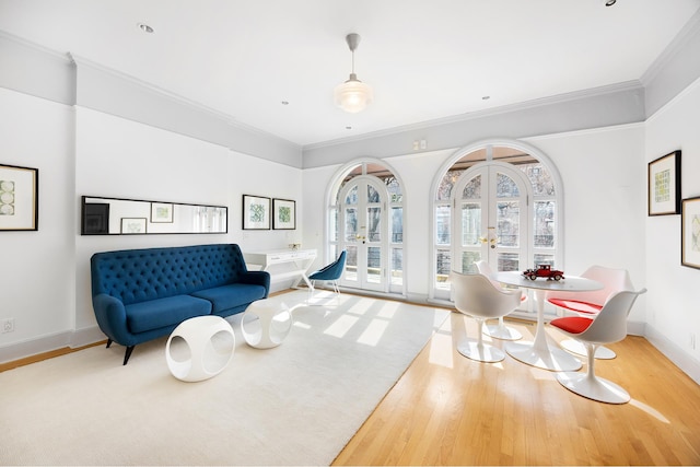 interior space with french doors, wood finished floors, and crown molding