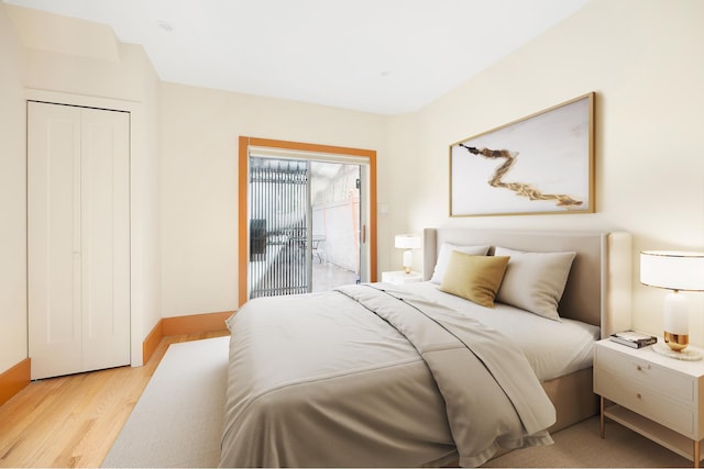 bedroom with light wood-style floors, access to outside, and baseboards