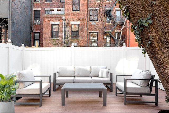 wooden deck featuring outdoor lounge area, fence, and cooling unit