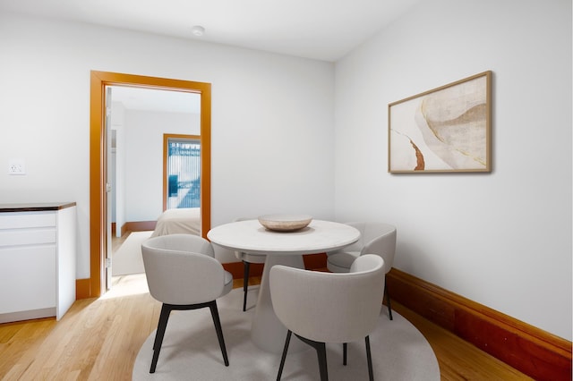 dining room featuring baseboards and light wood finished floors