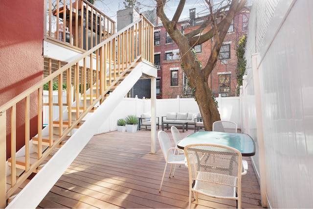 wooden deck with stairs, fence, and an outdoor living space