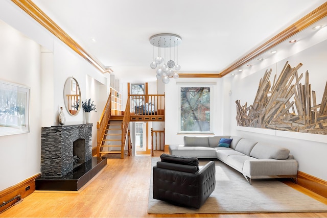 living room with a notable chandelier, stairway, wood finished floors, and a tile fireplace