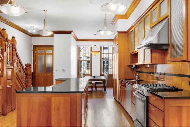 kitchen with brown cabinetry, dark countertops, light wood-style flooring, a center island, and stainless steel appliances