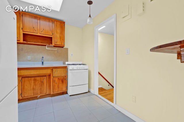 kitchen featuring brown cabinets, tasteful backsplash, light countertops, light tile patterned flooring, and white appliances