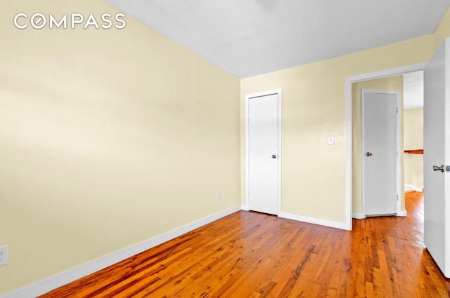 unfurnished bedroom featuring wood-type flooring and baseboards