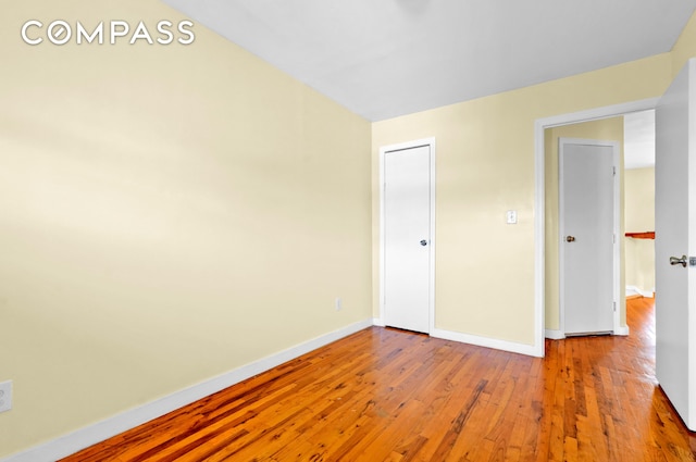 unfurnished bedroom with baseboards and wood finished floors