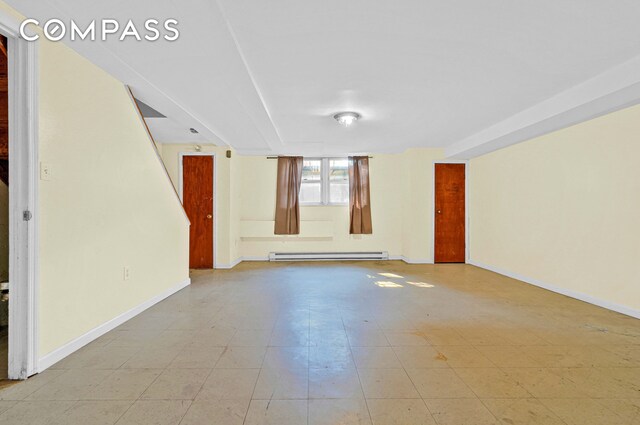 unfurnished room featuring baseboards, a baseboard radiator, and light floors