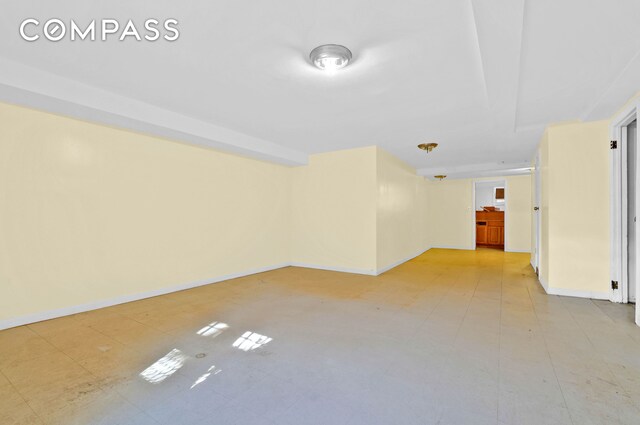 unfurnished room featuring light floors and baseboards