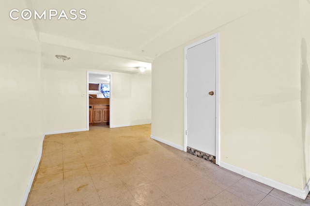 unfurnished room with baseboards