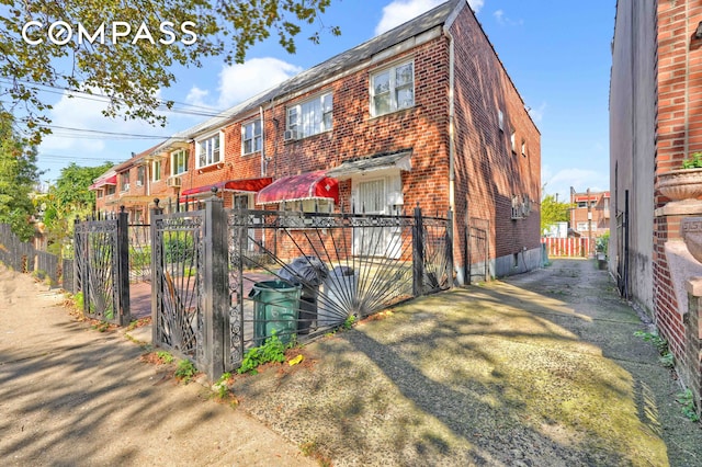 view of front of house with a gate, fence, and brick siding