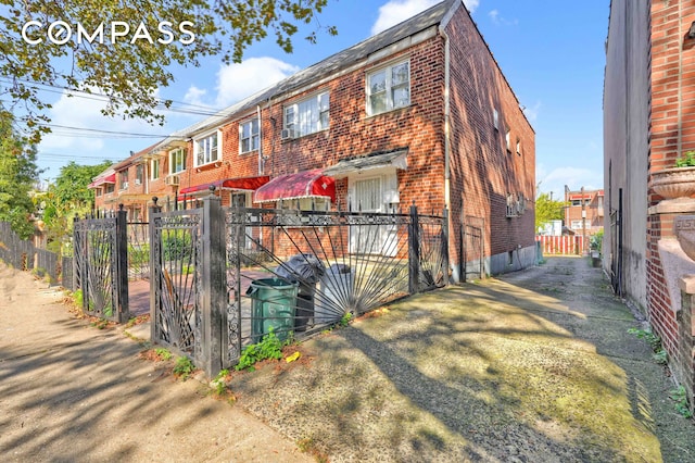 exterior space with brick siding, fence private yard, and a gate
