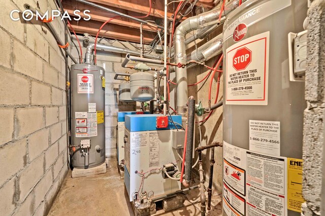 utility room with gas water heater and a heating unit