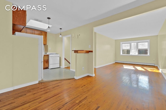 unfurnished living room with baseboards, a baseboard heating unit, visible vents, and light wood-type flooring