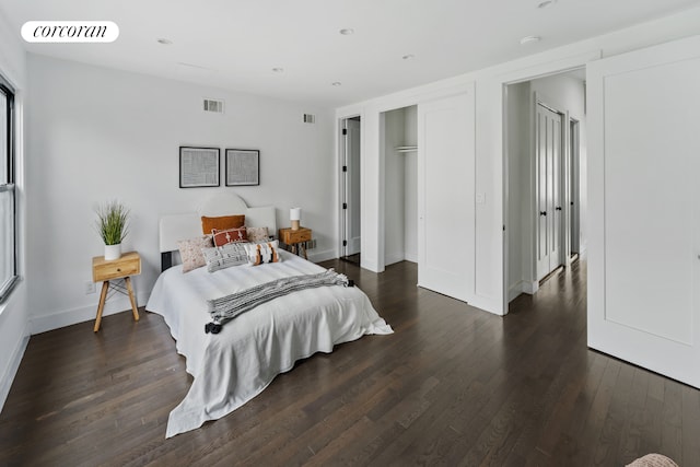 bedroom with dark wood-style flooring, visible vents, and baseboards